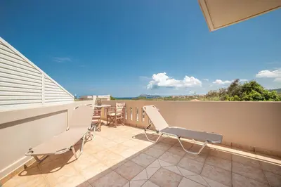 a patio with chairs and a table on a balcony at Mini Art Apartments in Gerani Chanion