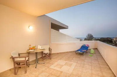 a balcony with a table and chairs on it at Mini Art Apartments in Gerani Chanion