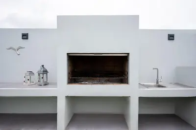 a white kitchen with a sink and a fireplace at Villa Giota in Chania Town