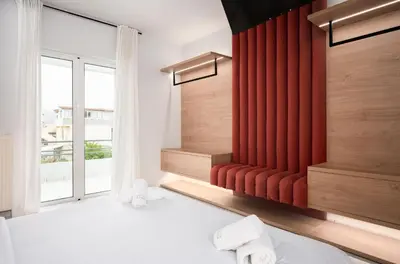 a bedroom with a red curtain and a bed with towels at Villa Giota in Chania Town