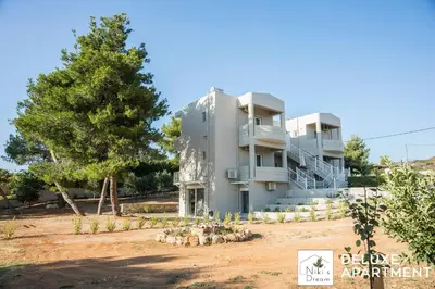 a large white building with a tree in front of it at Nikis Dream Comfy Apartments in Chania Town