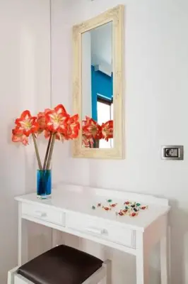 a white dressing table with a mirror and a vase with flowers at Kallitsakis Beach in Plataniás