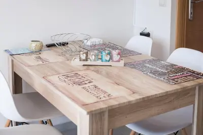 a wooden table with four white chairs around it at Athina Apartments Near The Sea Platania in Plataniás
