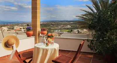 a table and chairs on a balcony with a view at Villa Meli-milon in Kolymvari