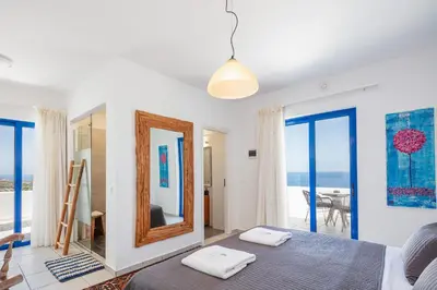 a bedroom with a bed and a mirror and a balcony at Villa Blanca Collection in Kalathas