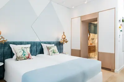 a white bed with a blue headboard in a room at Nyx Chic Manor in Chania Town
