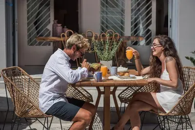 a man and woman sitting at a table eating food at Nyx Chic Manor in Chania Town