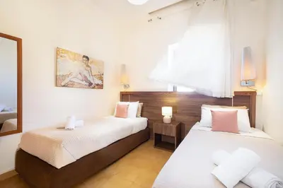 a bedroom with two beds and a mirror at Irini Apartment II in Kalyves