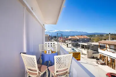 a balcony with chairs and a table on a balcony at Irini Apartment II in Kalyves