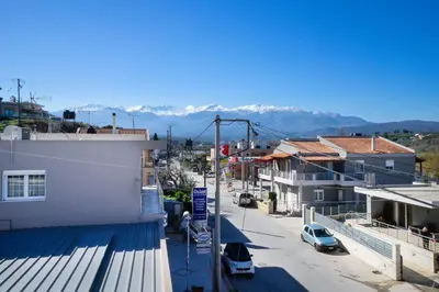 a city street with buildings and mountains in the background at Irini Apartment II in Kalyves