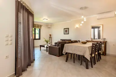 a dining room with a table and a couch at Villa Stellina in Marathokefála