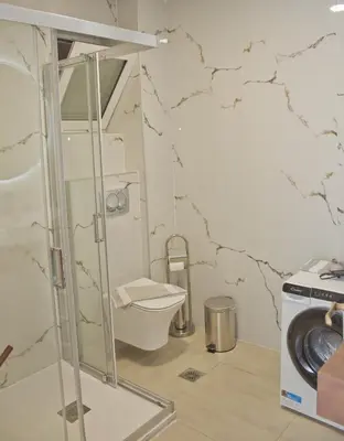 a bathroom with a toilet and a washing machine at Danaos Hotel in Chania Town