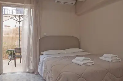 a bedroom with two towels on a bed with a window at Danaos Hotel in Chania Town