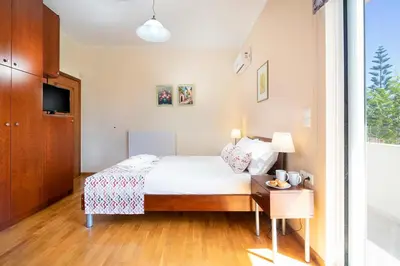a bedroom with a bed and a table with a lamp at Vrahokipos Villa in Kounoupidhianá
