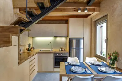 a kitchen with a table and chairs and a sink at La Casa Piccola in Chania Town