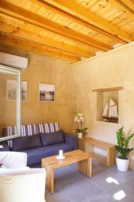 a living room with a blue couch and a table at La Casa Piccola in Chania Town