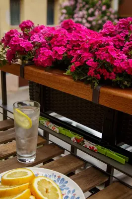 a glass of water with a lemon on a table with flowers at La Casa Piccola in Chania Town
