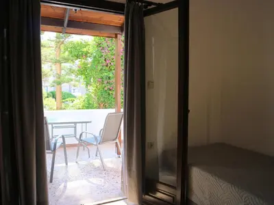 a sliding glass door leading to a patio with a table at Oliaria Apartments in Plataniás