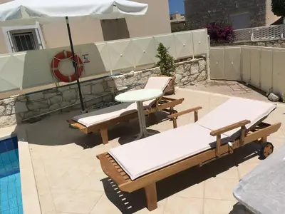 a patio with a table and chairs and an umbrella at Villa Nopigia Somina in Kissamos