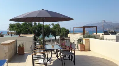 a table and chairs with an umbrella on a patio at Villa Nopigia Somina in Kissamos