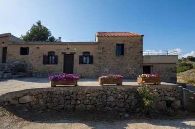 a stone house with three flower boxes in front of it at Lithari in Kámboi