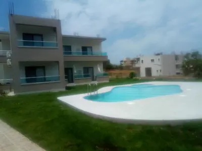 a swimming pool in front of a building at Efrilias Studios & Apartments in Kissamos