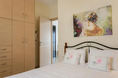 a bedroom with a bed with a painting on the wall at Mary Suites Chania in Chania Town