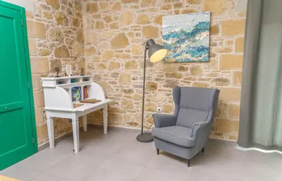 a room with a chair and a desk and a lamp at Villa Agrithea in Kissamos