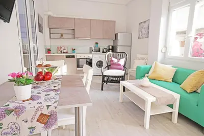 a living room with a green couch and a table at Mare Civitas Apartments in Chania Town