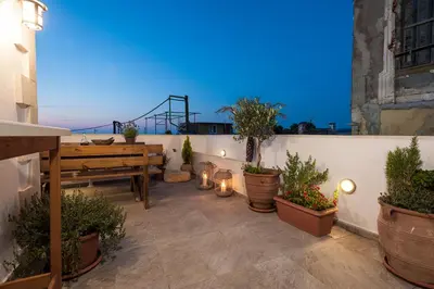 a patio with a wooden table and potted plants at Casa Eleni in Chania Town