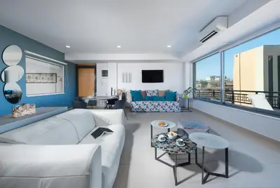 a living room with a white couch and a large window at Stefan's City Hub in Chania Town