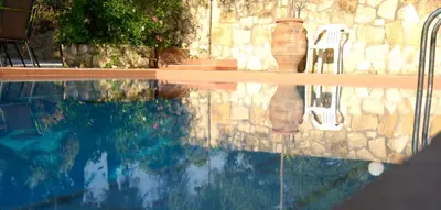 a pool of water with two vases sitting on top of it at Villa-Jasmin in Kato Daratso