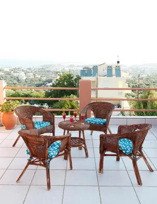 a group of chairs and tables on a balcony at Villa-Jasmin in Kato Daratso