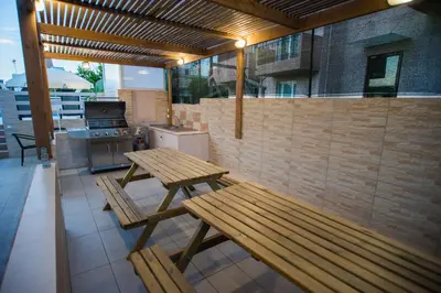 a patio with two wooden benches and a kitchen at Naiades Luxury Apartments in Kalathas