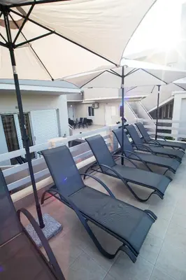 a row of chairs and umbrellas on a balcony at Naiades Luxury Apartments in Kalathas