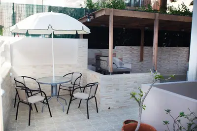 a table and chairs with an umbrella on a patio at Naiades Luxury Apartments in Kalathas