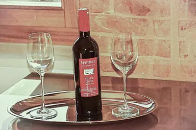 a bottle of wine on a tray with two wine glasses at Santrivani Rooms in Chania Town