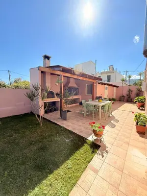 a backyard with a patio with a table and chairs at Villa Fanouris in Chania Town