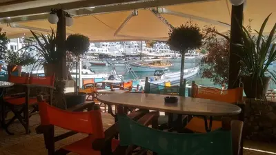 a restaurant with a marina with boats in the water at Loutro Holidays in Loutro