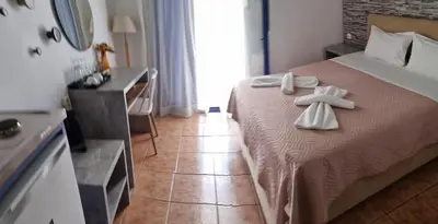 a bedroom with a bed with white towels on it at Loutro Holidays in Loutro