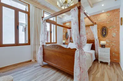 a bedroom with a canopy bed in a room at Hamam Suites Portou in Chania Town
