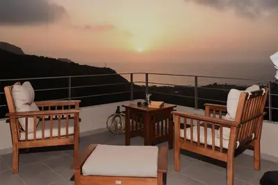 a balcony with two chairs and a table and the ocean at Villa Levande in Sfinárion