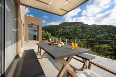 a patio with a table and a view of the mountains at Villa Levande in Sfinárion