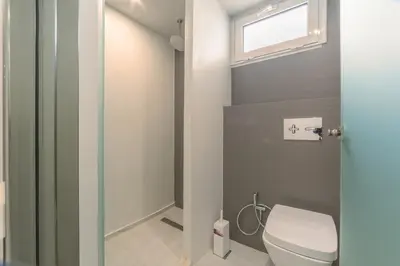 a bathroom with a toilet and a window at Atrion Resort Hotel in Agia Marina Nea Kydonias