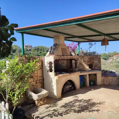 an outdoor oven with a roof on top of it at The Garden of Zephyrus - West in Kounoupidhianá