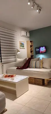 a living room with a large bed and a tv at The Garden of Zephyrus - West in Kounoupidhianá
