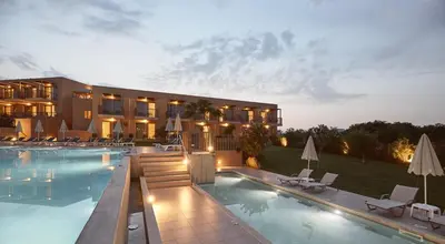 a hotel with a swimming pool in front of a building at Giannoulis – Santa Marina Beach Hotel in Agia Marina Nea Kydonias