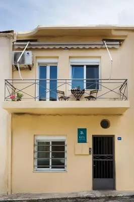 a building with a balcony with chairs on it at Kd's - Apartment in Chania Town