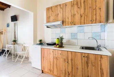 a kitchen with wooden cabinets and a sink at Kd's - Apartment in Chania Town