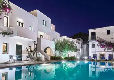 a villa with a swimming pool at night at Eva Suites & Apartments in Agia Marina Nea Kydonias